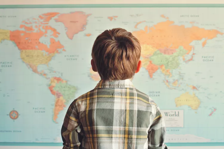 Young boy looking up at a map 